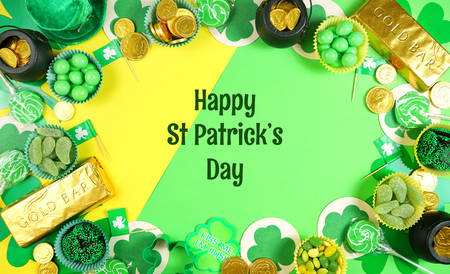 St Patricks Day flat lay with chocolate coins, leprechaun hat and shamrocks.
