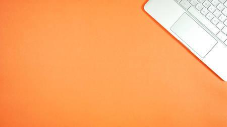 Personal pc laptop on bright color modern orange desktop overhead flatlay with negative copy space.の写真素材