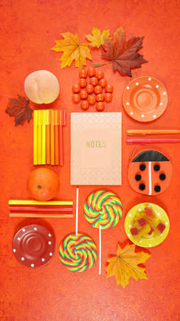 Back to School theme creative layout flat lay with school supplies, candy and stationery, autumn theme on textured orangeの写真素材