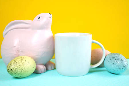 Easter product mockup with pink bunnies, easter eggs against yellow background.の写真素材