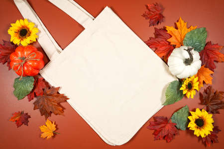Autumn leaves and pumpkins theme product mockup flatlay on brown backgroundの写真素材