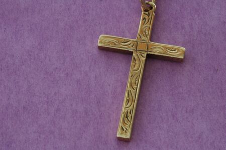 Gold cross on a purple backgroundの写真素材