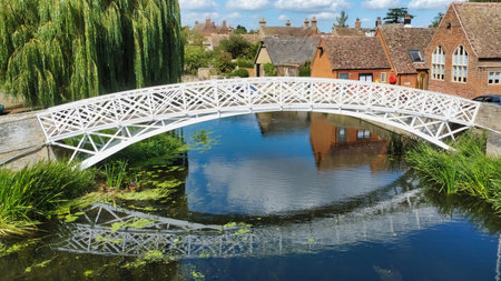 white bridge crossing a river in a townの写真素材