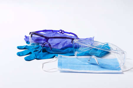 medical protective equuipment, nitrile gloves, mask for the face, blue, goggles, on a white...