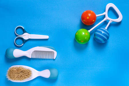 accessories for newborns, combs, scissors, rattles on a blue backround, top view
