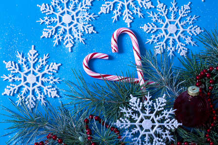 christmas tree and decorations, top view, on a blue background, snowflakes and lollipop, cane light...