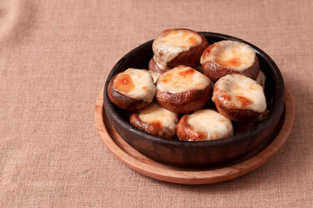 mushrooms baked with suluguni cheese on ketsi, a traditional Georgian dish, horizontal, no people