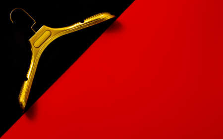 A gold clothes hangers on red and blackの写真素材