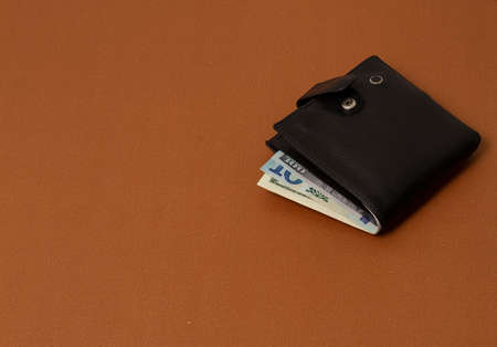 wallet with money, men`s black on a beige background, top view, horizontalの写真素材