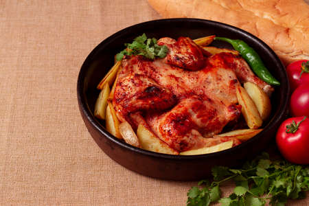 traditional georgian dish, tobacco chicken, with potatoes, on a wooden table, view from aboveの写真素材