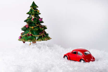 Christmas card, tree and red little car, toys, snow, on a white background, copy space, no people, horizontalの写真素材