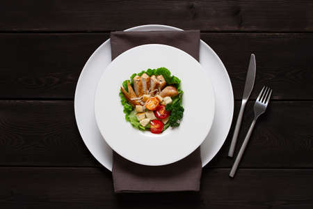 caesar salad with chicken on a black wooden tableの写真素材