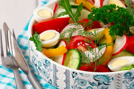 vegetable salad of tomato, cucumber, pepper, iceberg and quail eggs, on a white background, horizontal, nopeople, freshness, health, food, low-fat, natural, lifestyle, vegetable, vegetarian, restauranの写真素材