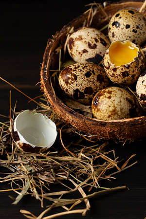 fresh quail eggs, in a plate of coconut, on a wooden brown table, top view,