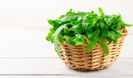 Fresh arugula leaves, in a basket, on a white table, macro, horizontal, no people,の写真素材