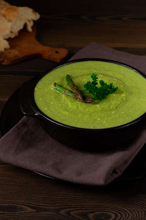 Cream soup, green asparagus, on a wooden background, healthy food, vertical, no people,の写真素材