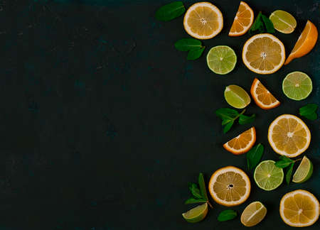 Background, sliced lime and lemon, citrus fruit, with mint, on a dark green table, top view, no people,の写真素材