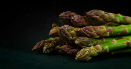 Bouquet of fresh asparagus, tied with a rope, vertically, on a dark background, no people,の写真素材