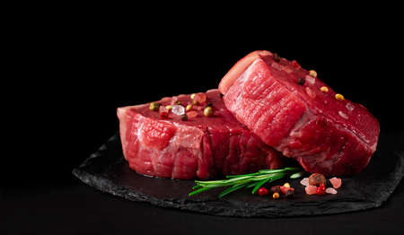 Beef steak, raw, mignon, with spices, on a black background, horizontal, no people,の写真素材