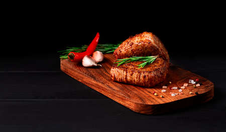 Beef steak, grilled, ribeye, with spices, on a wooden board, black table, horizontal, no people,の写真素材