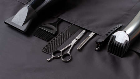 Professional barber tools, in the pocket, black stylist apron, horizontal, no people,の写真素材