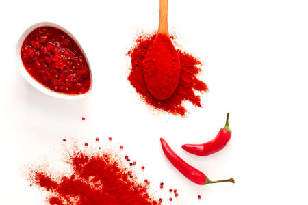 Hot red pepper, spoon, chili powder, pepper sauce, on a white background, selective focus, no...