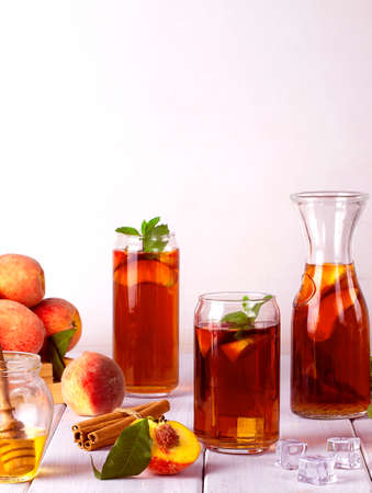 Peach tea, summer cold drink, with ice cubes and mint, on a white background, selective focus,の写真素材
