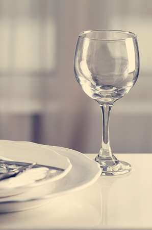 Wine glass and plates with cutlery, vertical, no people, serving, toned, selective focus,. High quality photoの写真素材