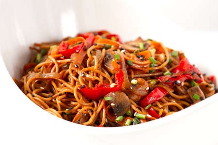 Udon noodles with mushrooms and vegetables, in sauce, with sesame seeds, Asian vegetarian food,...