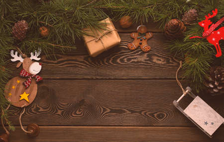 Background, Christmas tree branches, with cones and Christmas tree toys, on a wooden table, happy...