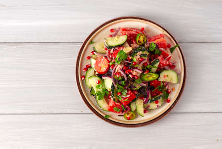 Traditional Georgian salad, Fresh vegetables, with walnut dressing, spices, herbs, pomegranate seeds, horizontal, no people,の写真素材