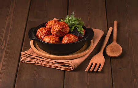Meatballs in tomato sauce, in a cast-iron frying pan, on a wooden table, rustic, horizontal , no people,. high quality photoの写真素材