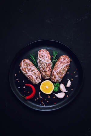 Traditional Cypriot Seftalia dish raw top view, on a black background, no people,