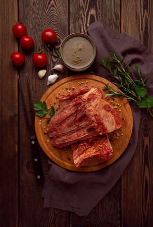 Smoked pork ribs on a wooden table, top view, sauce, tomatoes and spices, close-up, vertical, no people,の写真素材