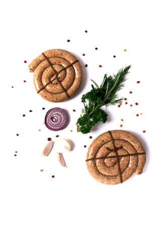 Two Raw spiral barbecue sausage on a white background, with spices and herbs, vertical, no people,