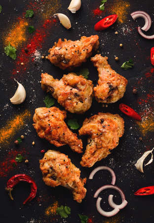 Fried chicken legs, breaded with spices and herbs, on a dark background, vertical, no people, selective focus, toned.の写真素材