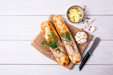 Baguette with garlic butter and herbs fried, on a white wooden table, no people,の写真素材