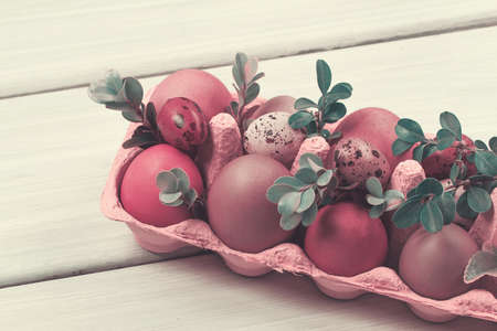 Easter eggs in a cardboard box, on a white wooden table, selective focus, horizontal,の写真素材