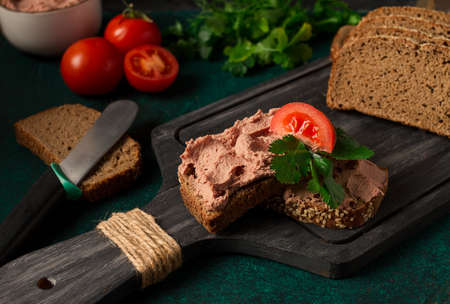 Liver meat pate spread on rye bread, breakfast close-up, dark background. no people, selective focus,の写真素材