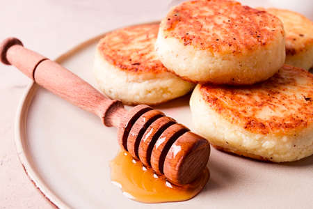 Cottage cheese pancakes with honey, close-up, on a beige table, selective focus, no people,