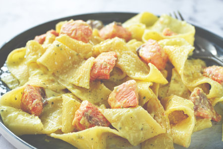 papardelle pasta, in creamy sauce with salmon, natural light, lifestyle, homemade, on a gray background, no people,の写真素材