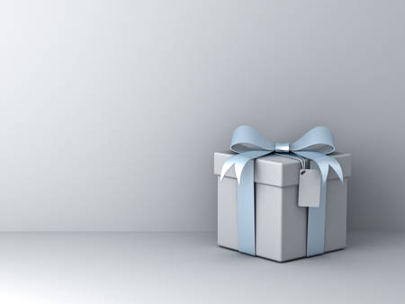 Gift box with silver blue ribbon bow and blank tag over white wall background with shadow abstractの写真素材