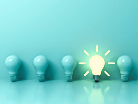 One glowing idea bulb standing out from unlit incandescent bulbs on light green pastel color background with reflection and shadow , individuality and different creative idea concepts . 3D rendering.の写真素材
