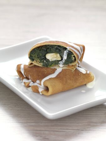 a pancake filled with cooked spinach and feta cheeseの写真素材