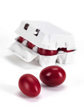 a carton box full of red boiled eggs and two out of the boxの写真素材