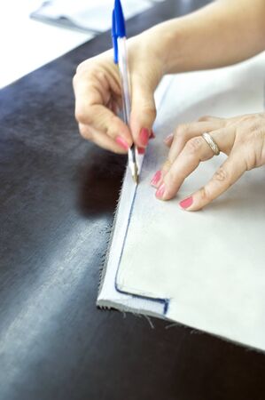 woman's hands drawing a fabric in a tailor's shop