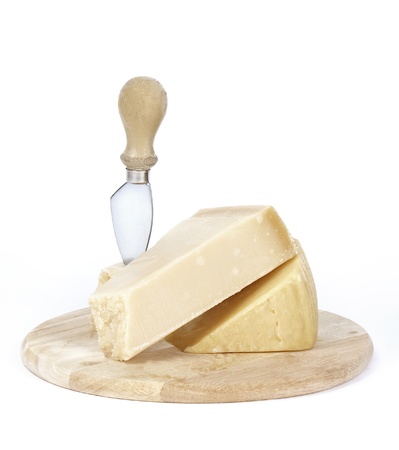 two pieces of cheese parmesan and reggato  on a wooden plate and a small knife for cutting cheeseの写真素材