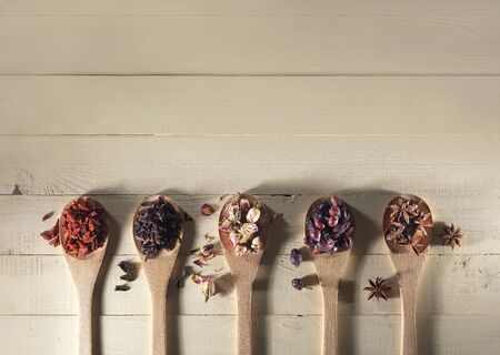 wooden spoons with spices and dried berriesの写真素材