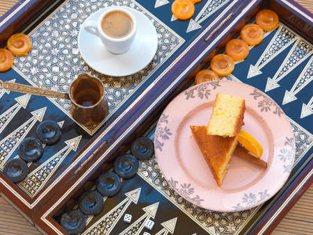 A traditional Greek sweet cake called ârevaniâ and greek coffee served on a backgammon .の写真素材