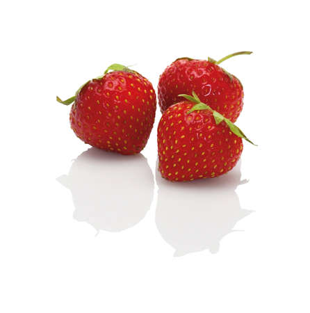 three fresh strawberries isolated on a white background,studio shot with a reflectionの写真素材